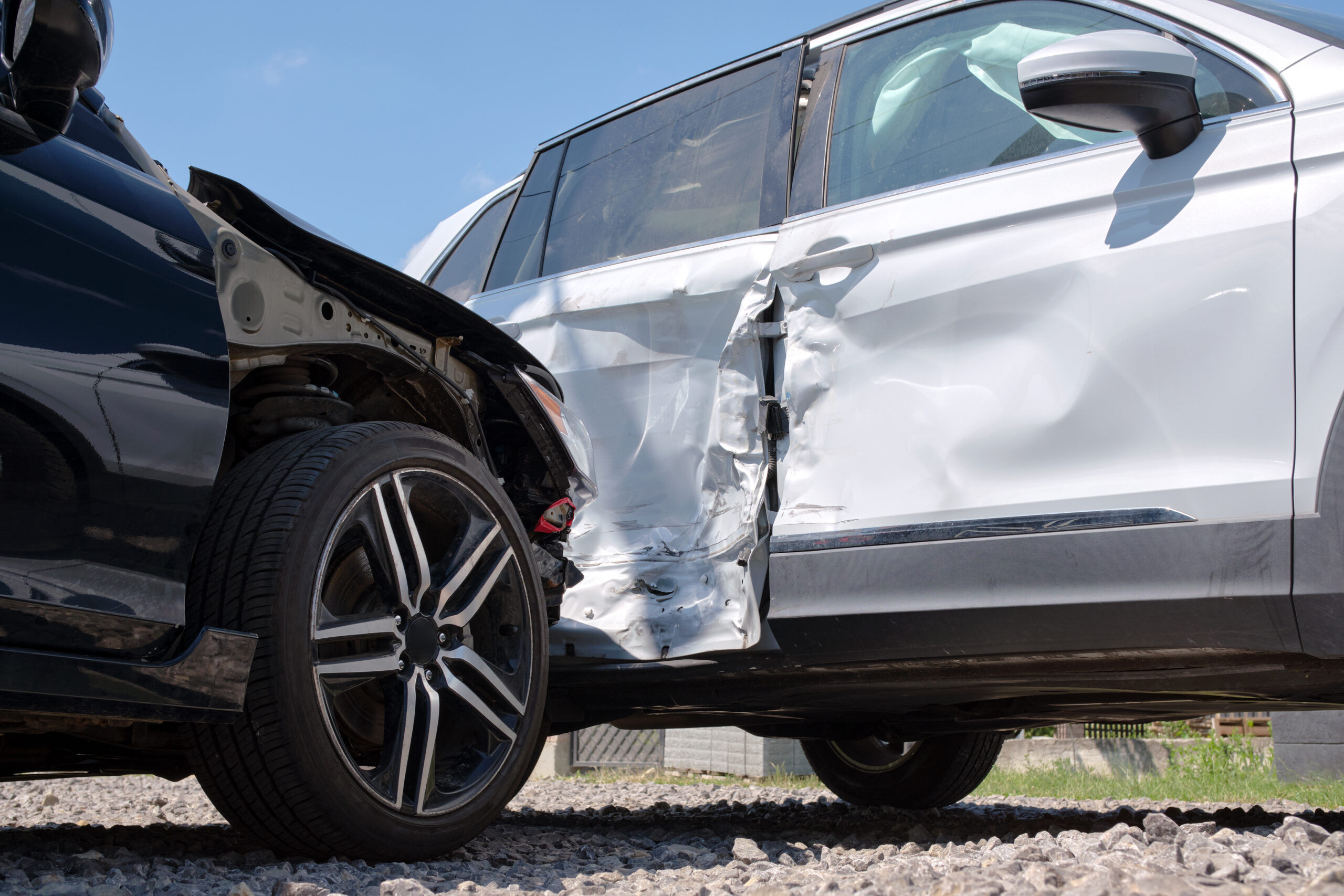 Damaged in heavy car accident vehicles after collision on city street crash site