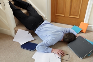 A man in business attire lies face down at the bottom of a staircase, surrounded by scattered papers, folders, and a pair of glasses, indicating a slip and fall accident while carrying work materials. A man in business attire lies face down at the bottom of a staircase, surrounded by scattered papers, folders, and a pair of glasses, indicating a slip and fall accident while carrying work materials.